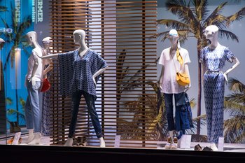 Esta llamativa exhibición utiliza colores, maniquíes, accesorios e imágenes para aumentar el atractivo visual de la ropa que se vende.