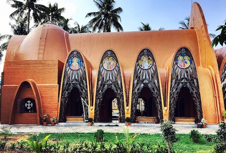 Una fotografía de una iglesia ortodoxa oriental en la India, construida con arcos curvos y una arquitectura inusual.