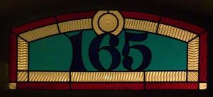 Imagen en color de una vidriera que muestra la casa número 165