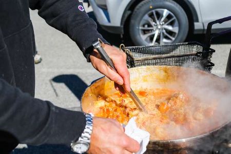 Un hombre revuelve una olla humeante de jambalaya.