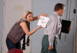 Foto de mujer colocando una nota sobre un compañero de trabajo