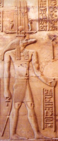 Una representación de Sobek con cabeza de cocodrilo y cuerpo humano sobre piedra arenisca de color tostado.