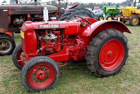 Un gran tractor rojo con grandes ruedas traseras.