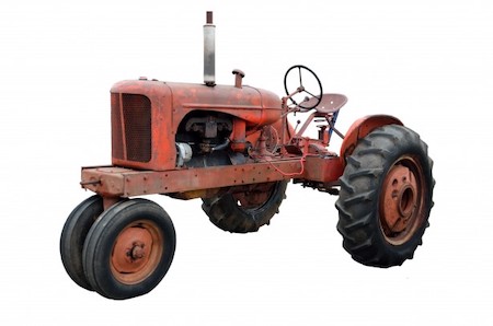 Un viejo tractor vintage rojo con dos grandes ruedas traseras