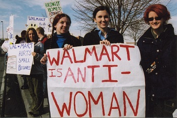 manifestante con un cartel que dice: Wal-Mart es anti-mujer