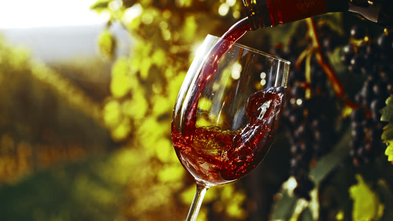 Botella de vino sirviendo en una copa de crital.