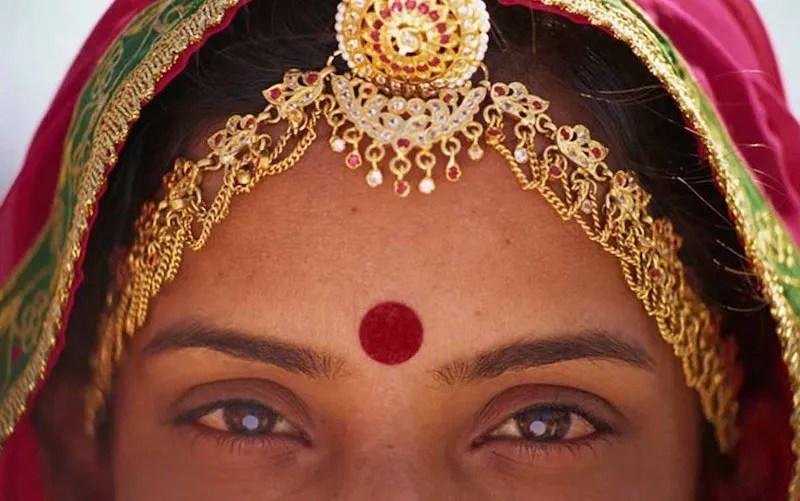 El bindi, colocado entre las cejas, simboliza el “tercer ojo”: un punto de conexión con la intuición, la sabiduría interior y la conciencia espiritual en la tradición hindú.